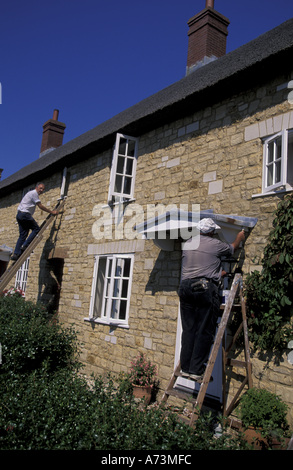 Europe, France, Régions, Abbotsbury. Les hommes travaillant sur old house Banque D'Images