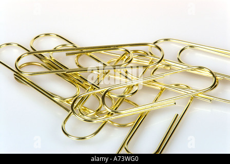 Des agrafes en laiton sur un fond blanc. Banque D'Images