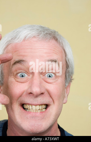 Portrait d'homme aux cheveux gris en colère à l'aide de mains pour exprimer des émotions Banque D'Images