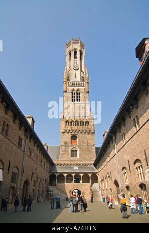 Vue verticale sur le beffroi pendu Bruges ou le Belfort van Brugge avec les touristes qui se promènaient dans la cour intérieure au soleil de Bruges. Banque D'Images