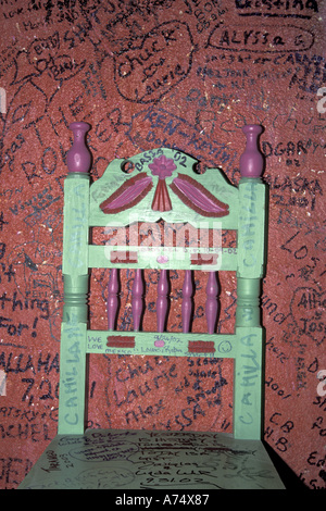 NA, le Mexique, la Basse-Californie, Todos Santos, l'Hôtel California. Tequila Sunrise Bar ; chaise face à un mur couvert de graffitis. Banque D'Images