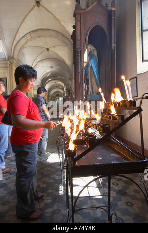 Femme de prière d'éclairage bougie dans la Cathédrale St Paul, Le Vigan Banque D'Images