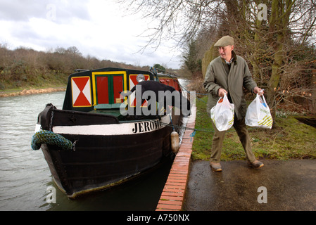 Un homme DESCEND D'UN CANAL PÉNICHE amarrée à l'EXTÉRIEUR D'UN MOULIN SUR LE Kennet and Avon près de Hungerford UK Banque D'Images