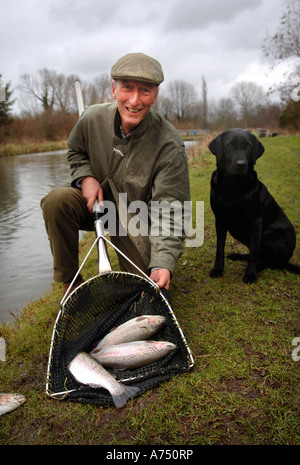 Un éleveur de poissons AVEC DES SPÉCIMENS DE TRUITE UK Banque D'Images