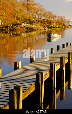 La fin de la lumière sur la jetée en bois et bateau à rames le Loch Lomond Ecosse UK Banque D'Images