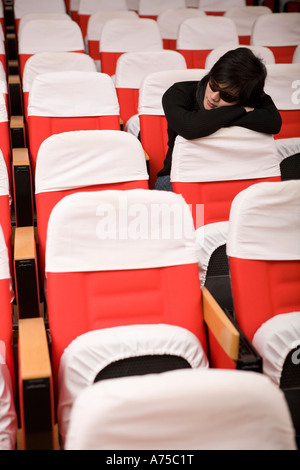 Student sleeping in empty classroom Banque D'Images