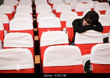 Student sleeping in empty classroom Banque D'Images