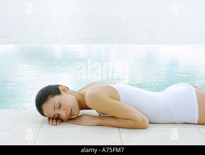 Femme sieste sur terre à bord de l'eau Banque D'Images