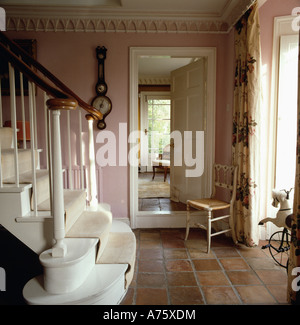 Carrelage en terre cuite en rose hall avec escalier blanc et mobilier chaise à côté gothique porte ouverte Banque D'Images