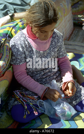 Jeune fille faire des bracelets à vendre aux touristes Blue Hole Dahab Egypte Mer Rouge Banque D'Images