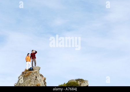 Jeune couple debout sur sommet de montagne, à l'écart Banque D'Images