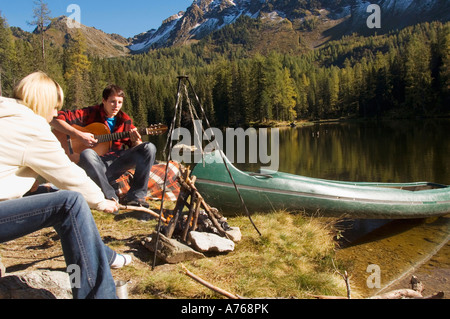 Jeune couple au lac, man playing guitar Banque D'Images