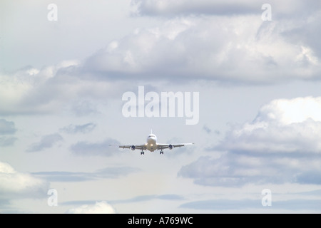 Un avion à réaction à venir à la terre vue de l'avant avec un ciel nuageux. Banque D'Images