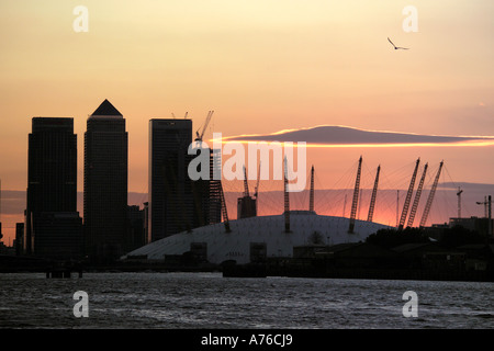 Coucher du soleil à Canary Wharf en silhouette avec le Millennium Dome maintenant appelé l'O2 Arena, au premier plan. Banque D'Images