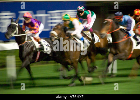 De près de l'chevaux galopant sont à la ligne d'arrivée avec le motion blur. Banque D'Images