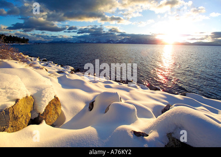 Neige fraîche sur la rive du lac Tahoe au coucher du soleil. Banque D'Images