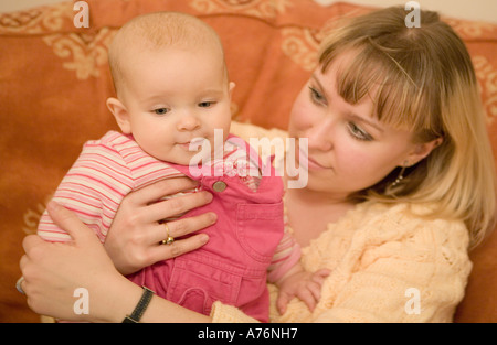 Mère avec vraiment cute baby girl de sept mois, à la maison - Des couleurs chaudes Banque D'Images