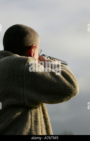 Homme veste polaire en visant le ciel en fusil de tir décembre Fête du comté d'Antrim en Irlande du Nord Banque D'Images