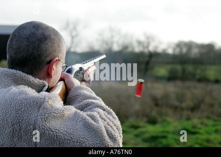 L'homme avec des lunettes de tir de fusil de chasse Veste polaire en champ avec l'éjection de la cartouche de tir décembre jour comté d'Antrim Banque D'Images