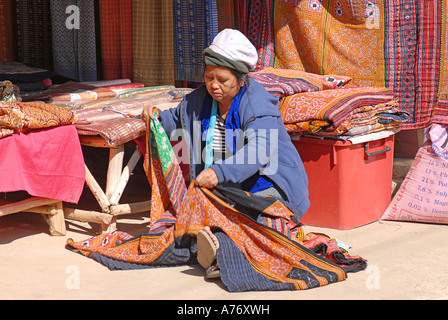 Femme Hmong distributeur tissus à partir de son étal Chiang Rai en Thaïlande Banque D'Images