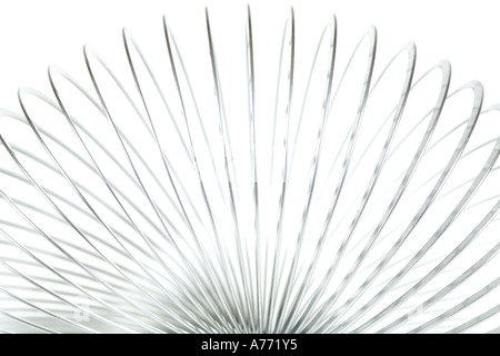 Ressort slinky métallique jouet sur un fond blanc, pur.. Banque D'Images