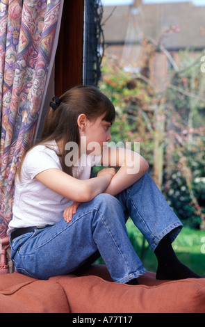 Jeune adolescente regardant par la fenêtre Banque D'Images