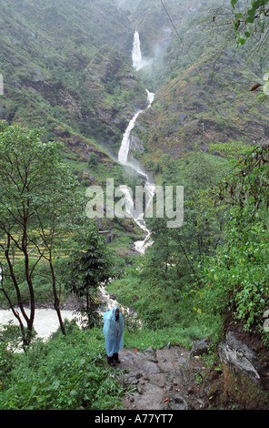Cascade et voyageur solitaire en premier plan dans la région de l'Annapurna Népal Syange environs Banque D'Images