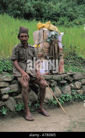 Porter népalais transportant des marchandises à vendre en haute montagne dans la région de l'Annapurna lieux rencontre près de Ngadi village Népal Banque D'Images