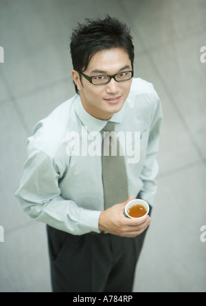 Businessman holding, tasse de thé, smiling at camera, portrait Banque D'Images