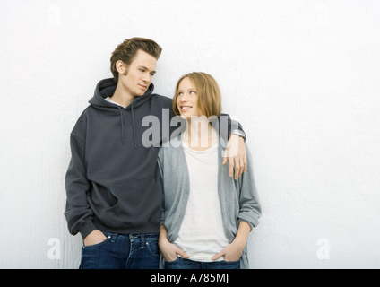 Jeune couple, l'homme avec le bras autour des épaules de la femme, à la femme vers lui Banque D'Images