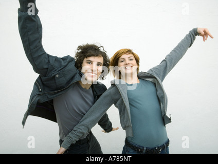 Jeune homme et jeune femme danse avec les bras, smiling at camera Banque D'Images
