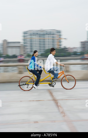 Jeune couple riding tandem Banque D'Images