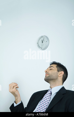 Businessman holding balle anti-stress, les yeux fermés Banque D'Images