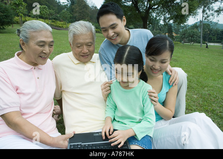 Three generation family, using laptop in park Banque D'Images