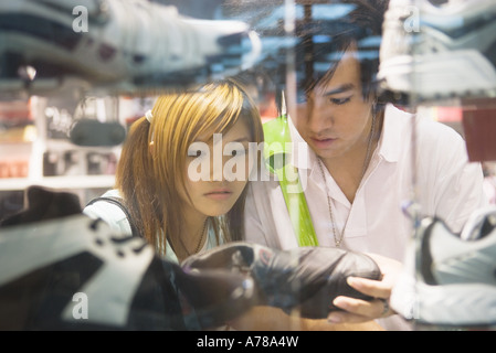 Jeune couple à la recherche de chaussures de sport dans le magasin Banque D'Images