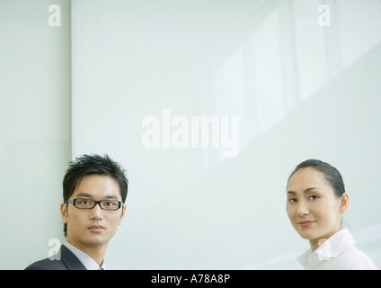 Businessman and businesswoman looking at camera, tête et épaules Banque D'Images