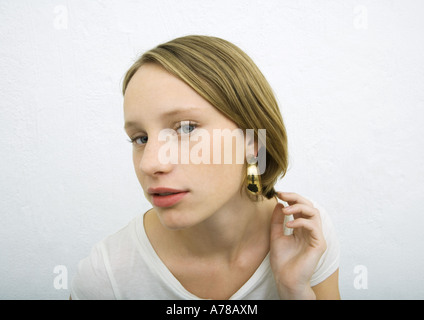 Teenage girl wearing earring looking at camera Banque D'Images