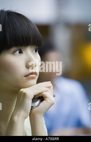 Young woman holding cell phone entre les mains Banque D'Images