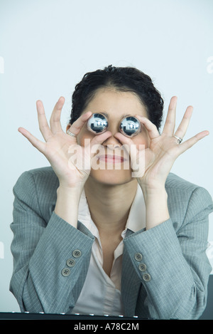 Businesswoman holding yinyang balls, en face des yeux Banque D'Images