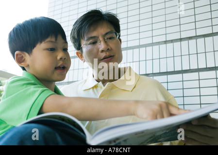 Père et fils à la recherche de livre ensemble Banque D'Images