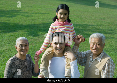 Trois génération de la famille, fille assise sur les épaules du père, des grands-parents holding hands, portrait Banque D'Images