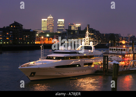 UK London Tamise et les Docklands de nuit bateau yacht amarré au quai de Tower Bridge Banque D'Images