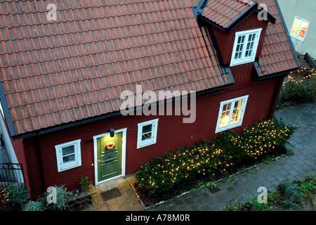 Soir s'installe sur un sol carrelé typique peint rouge cottage dans Norderklint Ville fortifiée médiévale de la ville hanséatique de Visby, Gotland Banque D'Images