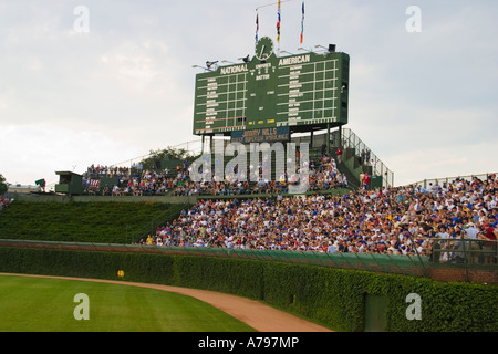 Chicago Illinois SPORTS jeu de nuit à Wrigley Field fans dans les gradins d'affichage traditionnel mur de lierre sur outfield Banque D'Images