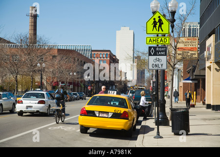 CHICAGO Illinois cycliste dans la voie cyclable désignée street sign sur l'après Wells Street femme sortir de taxi cab Banque D'Images