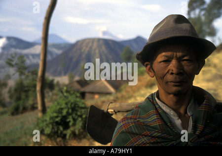 Agriculteur avec hoe les cultures sur les pentes du Mont Bromo visible en arrière-plan Java Indonésie Aucun MR Banque D'Images