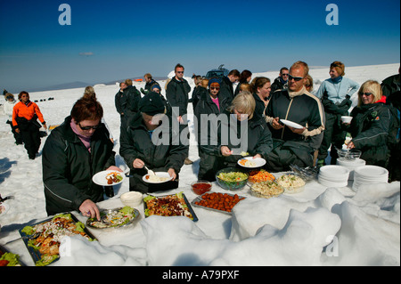 Les touristes de manger le déjeuner sur glacier, le glacier de Langjökull, Islande Banque D'Images