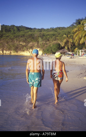 Couple marchant le long d'une plage à Antigua Modèle pas publié Banque D'Images