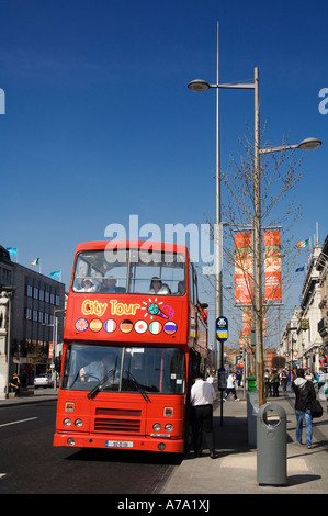 Un tour bus décapotable sur O'Connell Street avec la flèche à l'arrière-plan-Dublin Irlande Banque D'Images