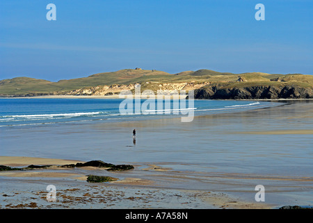 Personne solitaire pataugeant par lavage à l'Balnakeil Bay près de Durness à Sutherland en Écosse avec Faraid Head derrière Banque D'Images